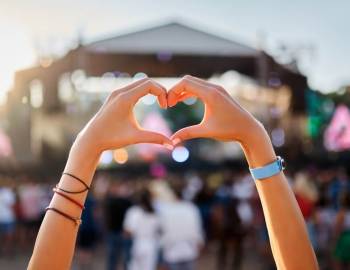 A woman making heart hands at the 2024 Fish and Grits Music Festival in Hilton Head