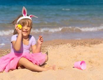 A little girl finds an Easter egg on the beach on Hilton Head Island