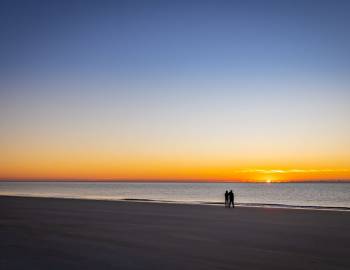 A couple standing on a beach in Hilton Head Island at sunset during spring break